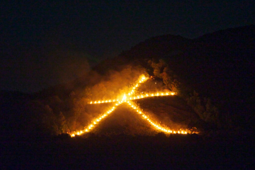 京都の夏の風物詩、五山送り火。送り火は保存会に属する地域住民が共同で行い、その信仰を受け継いでいる　めがねトンボ/ PIXTA（ピクスタ）